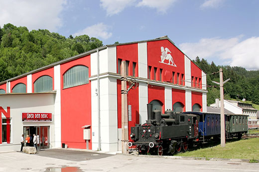 Blick auf das Südbahnmuseum, davor steht eine alte Dampflokomotive