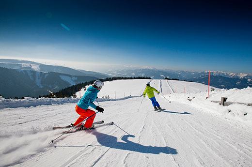 Zwei Skifahrer fahren die Piste hinunter